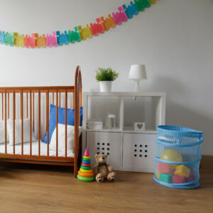 Photo of a simple design wooden cradle in a cozy baby bedroom