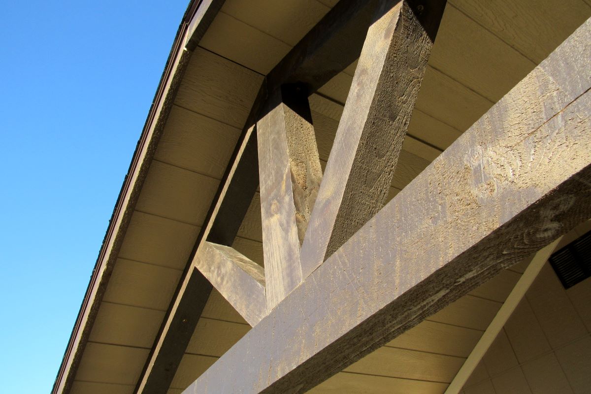 Close-up timber truss under shed roof on Amish shed kit, showing rough-sawn beams.